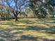 Large backyard with mature oak trees providing shade at 4680 Poinciana Dr, Indian Lake Estates, FL 33855