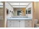 Bathroom with a shower, vanity, and a large mirror reflecting the view into another room at 4680 Poinciana Dr, Indian Lake Estates, FL 33855