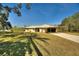 Single-story home with a covered carport and a spacious yard at 4680 Poinciana Dr, Indian Lake Estates, FL 33855