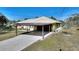 Carport and paved driveway with grassy area at 4680 Poinciana Dr, Indian Lake Estates, FL 33855