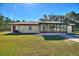 Exterior showing sunroom with a tile roof, a side door, manicured lawn, and an AC unit at 4680 Poinciana Dr, Indian Lake Estates, FL 33855