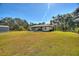 Back of house with sunroom and large backyard at 4680 Poinciana Dr, Indian Lake Estates, FL 33855