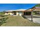 Single story home with covered carport and landscaped yard at 4680 Poinciana Dr, Indian Lake Estates, FL 33855