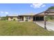 Single story house with covered carport and manicured lawn at 4680 Poinciana Dr, Indian Lake Estates, FL 33855