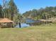 Serene lake view with lush vegetation and a gazebo at 4680 Poinciana Dr, Indian Lake Estates, FL 33855
