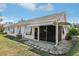 Backyard with an awning-covered, screened lanai on a well-maintained lawn at 515 Torres Pl, Lady Lake, FL 32159