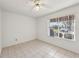 Bedroom features tile floors, a ceiling fan, and a window with a view of the front yard at 515 Torres Pl, Lady Lake, FL 32159