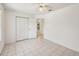 Bright bedroom with neutral walls, tiled floors, and a ceiling fan with ample closet space at 515 Torres Pl, Lady Lake, FL 32159