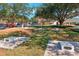 Outdoor cornhole area with multiple boards on a grassy field, surrounded by trees, golf carts, and residential buildings at 515 Torres Pl, Lady Lake, FL 32159