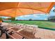 Outdoor recreation area with shaded picnic tables and benches overlooking a manicured green lawn under a partly cloudy sky at 515 Torres Pl, Lady Lake, FL 32159