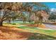 Scenic view of a paved path winding through a landscaped area with Spanish moss-covered trees and a glimpse of the water at 515 Torres Pl, Lady Lake, FL 32159