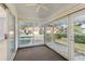 Enclosed sunroom featuring sliding glass doors and a ceiling fan overlooking the landscaped front yard at 515 Torres Pl, Lady Lake, FL 32159