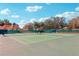 An outdoor tennis court with a green playing surface and surrounded by well-maintained landscaping on a sunny day at 515 Torres Pl, Lady Lake, FL 32159