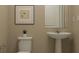 Small bathroom with pedestal sink, toilet, and framed art at 7310 Ivy Tendril Ave, Orlando, FL 32829