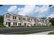 Front view of townhouses with gray siding, white trim, and landscaping at 7310 Ivy Tendril Ave, Orlando, FL 32829