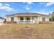 House exterior featuring beige siding, a covered porch, and a neat lawn at 20 Hemlock Trl, Ocala, FL 34472