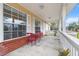 Covered porch with red chairs and plants, offering a relaxing outdoor space at 20 Hemlock Trl, Ocala, FL 34472