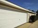 Attached garage with white door and landscaping at 20 Hemlock Trl, Ocala, FL 34472