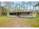 Mobile home exterior with screened porch, landscaped yard, and wooded surroundings at 2519 State Park Rd, Lakeland, FL 33805