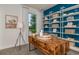 Home office with wooden desk, shelving, and a blue accent wall at 6805 Sw 90Th Loop, Ocala, FL 34476