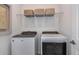 Laundry room with Whirlpool washer and dryer and overhead shelving at 6805 Sw 90Th Loop, Ocala, FL 34476