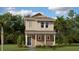 Two-story house with light beige exterior, gray roof, and a small front porch at 1922 Rider Rain Ln, Apopka, FL 32703