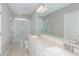 Stylish bathroom featuring double sinks, quartz countertops, a large mirror, and a modern glass shower at 6822 Sw 90Th Loop, Ocala, FL 34476