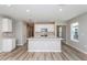 Bright, modern kitchen featuring white cabinets, stainless steel appliances, and an expansive center island at 6822 Sw 90Th Loop, Ocala, FL 34476