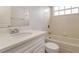 Bathroom featuring tiled shower over tub, window, and vanity sink with storage at 2504 Davenport Cir, Kissimmee, FL 34746