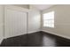 Bedroom featuring dark wood floors, a window with natural light, and closet with paneled doors at 2504 Davenport Cir, Kissimmee, FL 34746