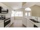 Modern kitchen with white cabinets, stainless steel appliances, and an adjacent dining area at 2504 Davenport Cir, Kissimmee, FL 34746