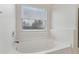 Relaxing bathroom with garden tub, window, and white finishes at 2804 Grasmere View Pkwy, Kissimmee, FL 34746