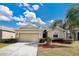 Tan house with a two-car garage and well-manicured lawn at 3723 Madbury Cir, Lakeland, FL 33810