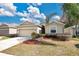 Tan house with two-car garage and neatly landscaped yard at 3723 Madbury Cir, Lakeland, FL 33810