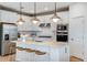 Modern kitchen with stainless steel appliances, white cabinetry, a kitchen island, and pendant lighting at 6785 Sw 90Th Loop, Ocala, FL 34476