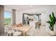 Open-concept dining area leading to a modern kitchen, featuring a large window and stylish decor at 6788 Sw 90Th Loop, Ocala, FL 34476