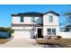 Two-story house with solar panels, white siding, and a two-car garage at 430 Stillwater Ln, Haines City, FL 33844