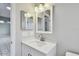 Bathroom featuring a white vanity with a modern faucet and rectangular framed mirrors at 683 Anderson Dr, Deltona, FL 32725