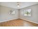 Bright bedroom with wood-look floors, ceiling fan, and two windows for natural light at 683 Anderson Dr, Deltona, FL 32725