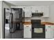 Modern kitchen with black appliances and wood countertops for a sleek design at 683 Anderson Dr, Deltona, FL 32725