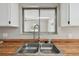 Close-up of a stainless steel kitchen sink and wood countertops with a large window view at 683 Anderson Dr, Deltona, FL 32725