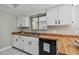 Modern kitchen sink with wood countertops, white cabinets, and stainless steel faucet at 683 Anderson Dr, Deltona, FL 32725