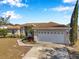 Tan house with white garage door and landscaping at 1371 Laurel Glen Dr, Bartow, FL 33830