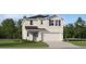 Two-story house with beige siding, gray roof, and a two-car garage at 858 Hour Glass Rd, Lakeland, FL 33801