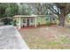 Green house exterior with covered porch and landscaping at 11730 Sw 230Th Avenue Rd, Dunnellon, FL 34431