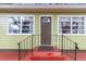 Front door entrance with a black metal railing and steps at 11730 Sw 230Th Avenue Rd, Dunnellon, FL 34431