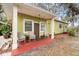 Inviting front porch with two wicker chairs and red flooring at 11730 Sw 230Th Avenue Rd, Dunnellon, FL 34431