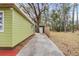 Green house exterior with a long driveway and storage shed at 11730 Sw 230Th Avenue Rd, Dunnellon, FL 34431