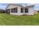 View of the house exterior, highlighting the addition and lawn at 1309 Ballesteros Dr, The Villages, FL 32162