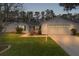 Inviting home exterior featuring a two-car garage and well-manicured lawn at 1309 Ballesteros Dr, The Villages, FL 32162